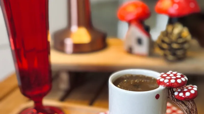 Warm chaga functional mushroom tea in a whimsical mushroom cup, red accents, cozy indoors setting.