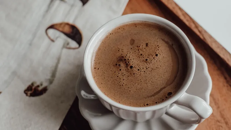 A cup of coffee elegantly presented on a wooden tray beside a mushroom-illustrated napkin
