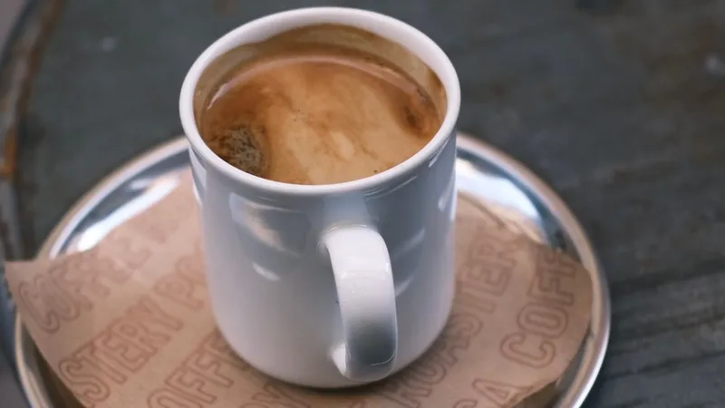 A hot cup of mushroom coffee on a rustic outdoor cafe table, inviting warmth and relaxation.